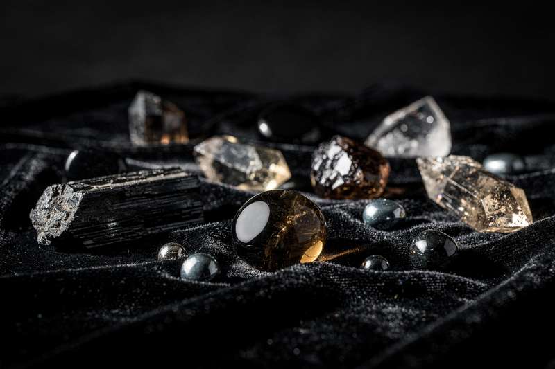 Black tourmaline and amethyst stones arranged together for energetic protection and aura shielding.