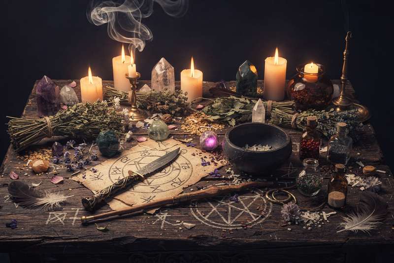 Candles, crystals, and written intentions arranged on an altar for casting a manifestation spell.
