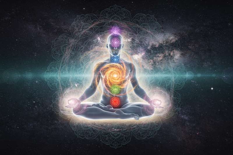 Peaceful practitioner in yin yoga pose holding a gentle stretch to align and balance the body's seven energy centers.